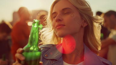 年轻的女人喝啤酒迪斯科微笑女孩跳舞日落屋顶聚会，派对
